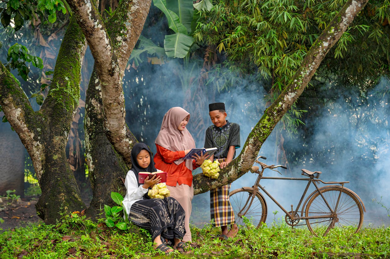 Children sitting by a tree reading books on a misty day in Banten, Indonesia.